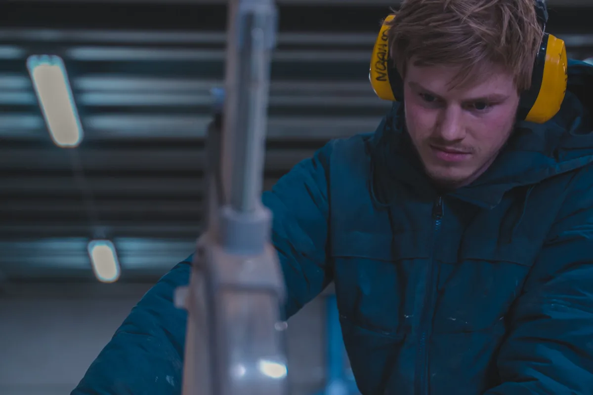 Medewerker aan de zaagmachine in de fabriek van IT Mammoet in Purmerend